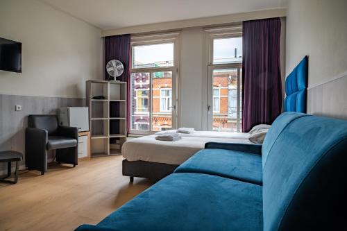 a hotel room with a bed and a chair at Hotel Kap City Centre in Amsterdam