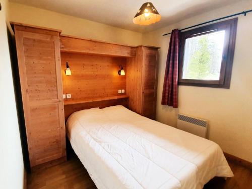 une petite chambre avec un lit et une fenêtre dans l'établissement Les Chalets Des Rennes - Appartement 2 pièces - Les Chalets Des Rennes MAE-9764, à Vars