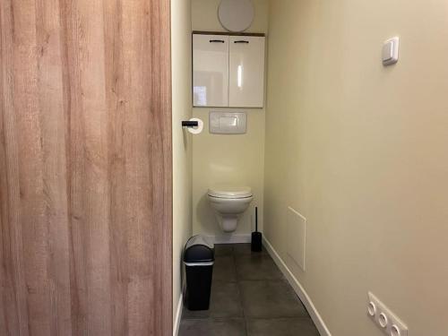 a bathroom with a toilet and a wooden door at TiLLEY lounge Tiny house in Vinça