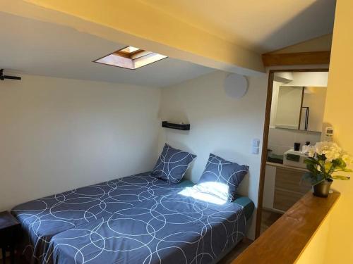 a bedroom with a blue bed in a room at TiLLEY lounge Tiny house in Vinça