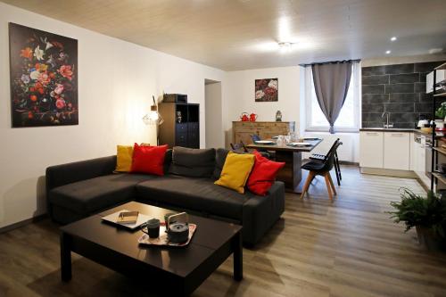 uma sala de estar com um sofá e uma mesa em L'Atelier 57 - Votre meublé authentique ! em Arbois