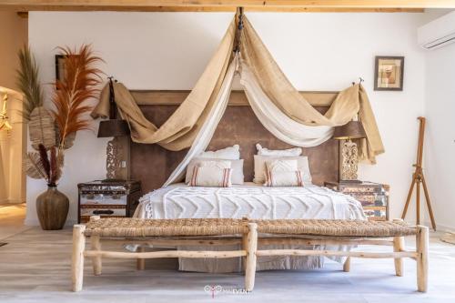 - une chambre avec un lit à baldaquin et un banc dans l'établissement VILLA CARBO Chambre d'hôtes Mourillon, 4 belles chambres, Piscine, à Toulon