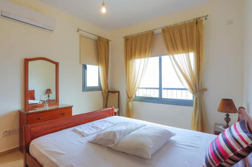 a bedroom with a bed and a mirror and a window at Villa Angelena in Droushia
