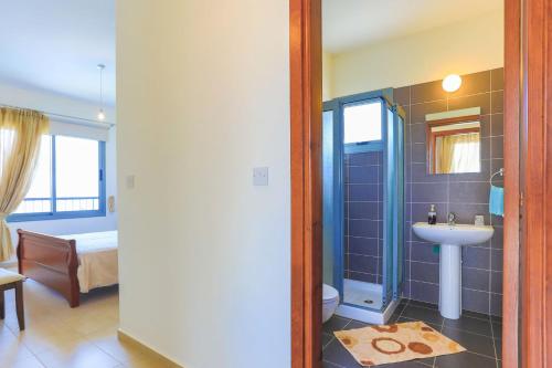 een badkamer met een wastafel en een douche met een toilet bij Villa Angelena in Droushia