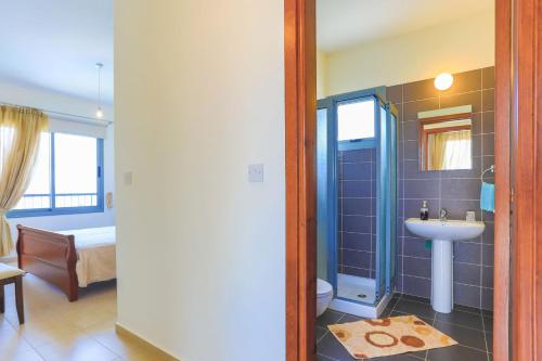 a bathroom with a sink and a shower with a toilet at Villa Angelena in Droushia