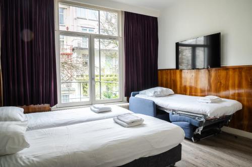 Habitación con 2 camas y ventana en Hotel Kap City Centre, en Ámsterdam