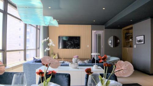 a living room with a blue couch and flowers in vases at Masingita Towers Hotel and SPA in Johannesburg