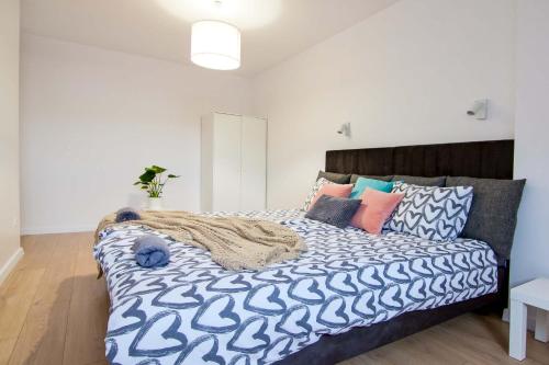 a bedroom with a large bed with blue and white sheets at Apartament Chełm City in Chełm