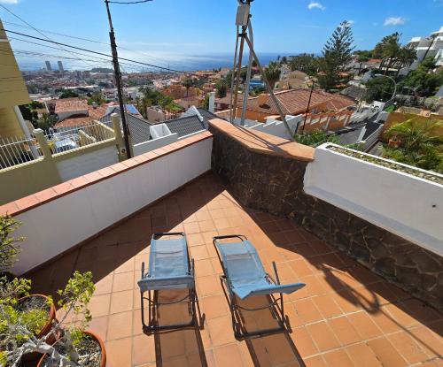twee blauwe stoelen op een patio met uitzicht bij Apartamento Drago in Santa Cruz de Tenerife