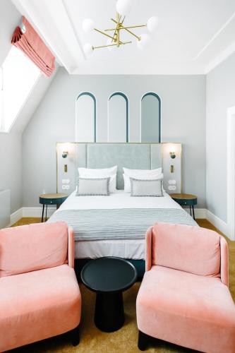 a bedroom with a bed and two chairs at Hotel Altus Palace - Destigo Hotels in Wrocław