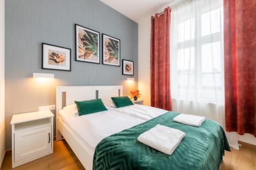 ソポトにあるVictus Apartamenty, Apartamenty Villa Victusのベッドルーム1室(緑のシーツが敷かれたベッド1台、窓付)