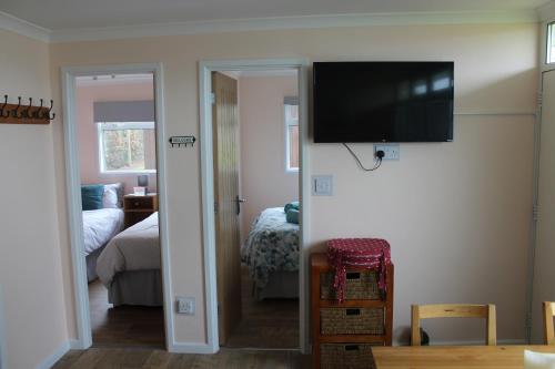 a living room with a flat screen tv on the wall at Stonesthrow in Stalham