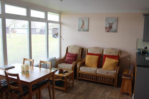 a living room with a table and a couch and a table and chairs at Stonesthrow in Stalham
