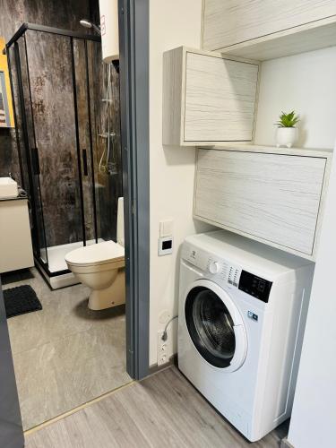 uma máquina de lavar roupa na casa de banho com WC em Modern Studio Apartment in Riga em Riga