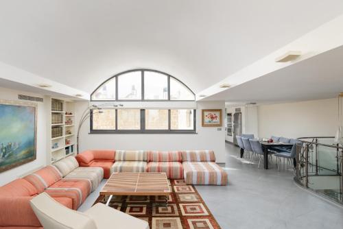 un soggiorno con divano e tavolo di Old City Luxury Duplex with Rooftop by FeelHome a Gerusalemme