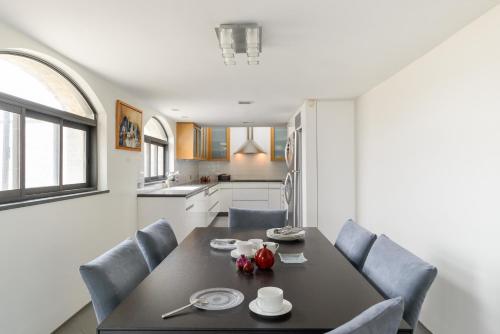 エルサレムにあるOld City Luxury Duplex with Rooftop by FeelHomeのキッチン(ダイニングルームテーブル、椅子付)