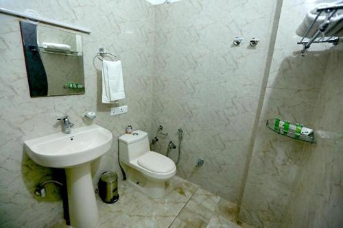 uma casa de banho com um WC, um lavatório e um chuveiro em The Roxxy Royal Resort em Rishikesh