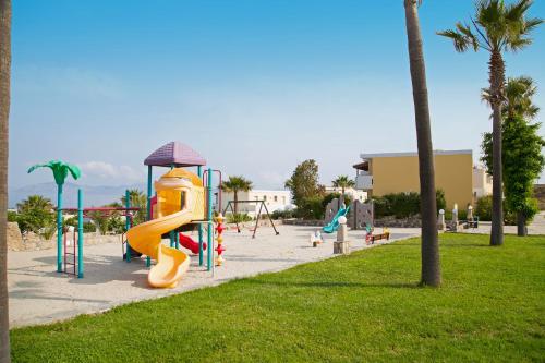 a playground with a slide in a park at Kouros Palace in Mastihari