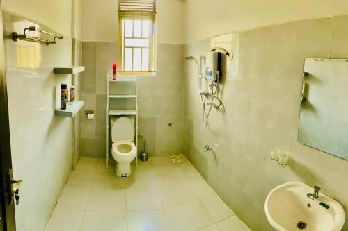 een badkamer met een toilet en een wastafel bij StarHomes, Jinja in Jinja