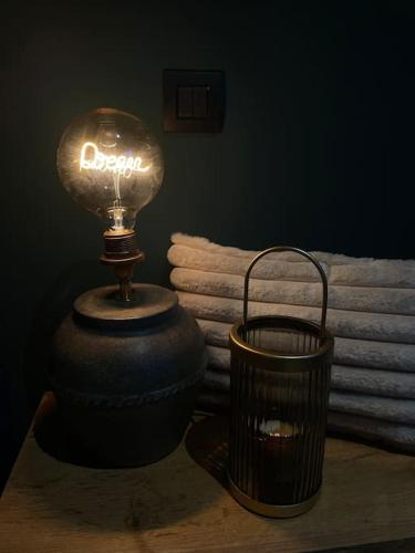 eine Lampe auf einem Tisch neben einem Mülleimer in der Unterkunft Lodge Spa privatif Le Revella in Profondeville