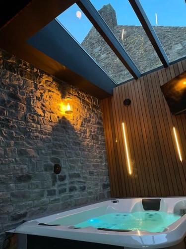 eine große Badewanne im Bad mit Fenster in der Unterkunft Lodge Spa privatif Le Revella in Profondeville
