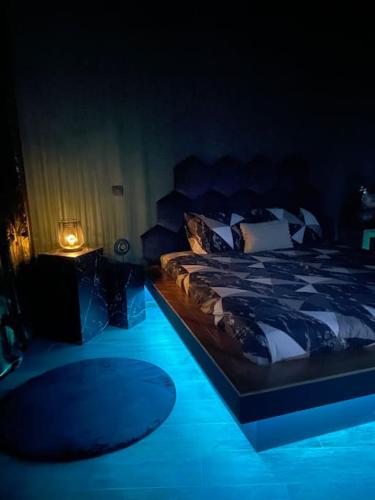 een slaapkamer met een bed met een blauw licht bij Lodge Spa privatif Le Revella in Profondeville