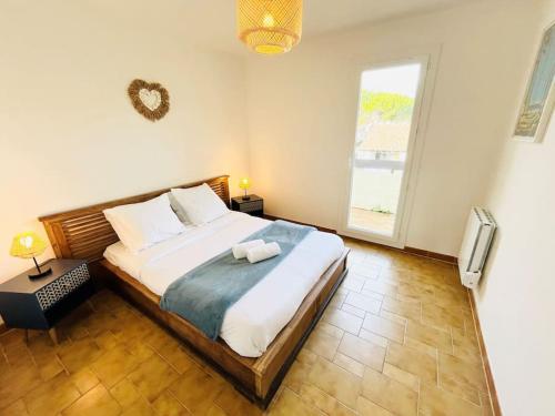 une chambre avec un grand lit et une fenêtre dans l'établissement Cosy Appartement, Proche mer, à Saint-Cyr-sur-Mer