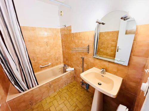 une salle de bain avec un lavabo, une baignoire et un miroir dans l'établissement Cosy Appartement, Proche mer, à Saint-Cyr-sur-Mer