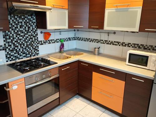 拉多姆的住宿－Apartament Sol，厨房配有水槽和炉灶 顶部烤箱