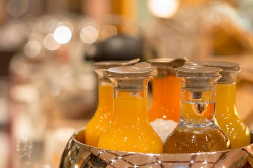 three bottles of orange juice in a metal container at Hotel Krone Unterstrass in Zürich
