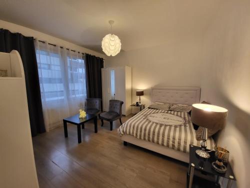 una camera da letto con un letto, due sedie e una lampada di Annecy Dream Appart ad Annecy