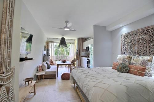 a bedroom with a large bed and a dining room at La Suite Serendipity piscine et plage in Saint-François