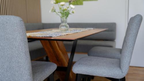 un tavolo con due sedie e un vaso di fiori sopra di Eva Apartments - Patscherkofel a Innsbruck