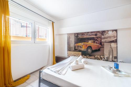 een hotelkamer met een bed en een poster van een gele auto bij Oasis Studios in the City Centre in Heraklion