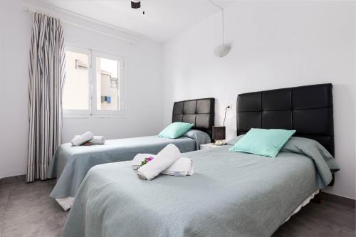 a bedroom with two beds and a window at Acapulco Apartments in Can Picafort