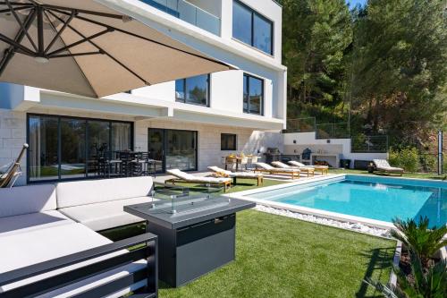 a backyard with a swimming pool and a villa at Villa Sunset Split overviewing Split and Podstrana bay in Strožanac