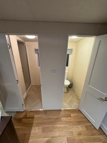 an empty bathroom with a toilet and a door at Golden sands holiday park- pitch H84 in Cockwood