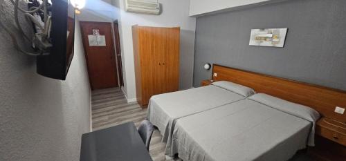 um quarto de hotel com uma cama e um corredor em Pensión España 2 Estrellas Cehegin em Cehegín