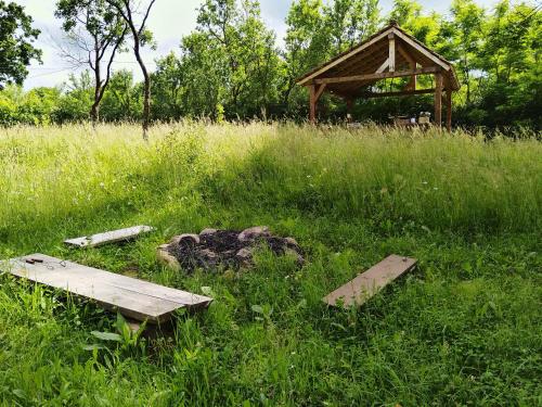 a wooden bench sitting in the grass with a gazebo at Big family Apartment in Breb's Cosy Barn in Breb