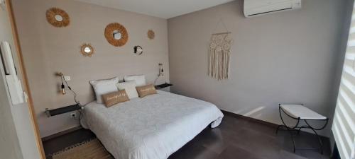 Maison de vacances avec piscine proche mer et montagne في جيزنوكسيا: غرفة نوم بيضاء مع سرير وطاولة