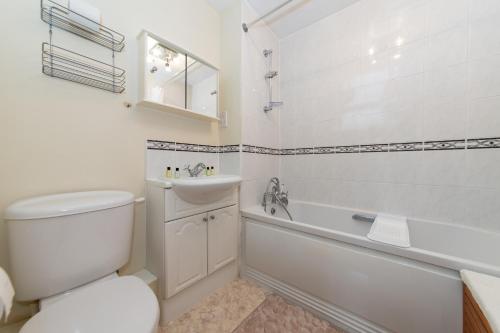uma casa de banho com um WC, uma banheira e um lavatório. em Large Tranquil Riverside Flat with Thames Views - Pass the Keys em Reading