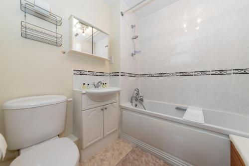 a bathroom with a toilet and a tub and a sink at Large Tranquil Riverside Flat with Thames Views - Pass the Keys in Reading