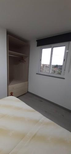 a white room with a bed and a window at Casa da Catraia - Remodelação recente nos quartos in Póvoa de Midões