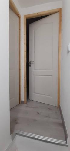 two white doors in a room with a concrete floor at Casa da Catraia - Remodelação recente nos quartos in Póvoa de Midões