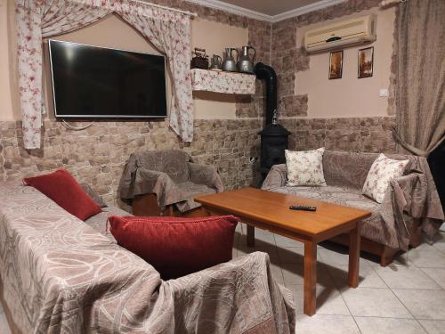 sala de estar con TV en una pared de ladrillo en Katerina studios rooms-Biker friendly hotel, en Kastoria