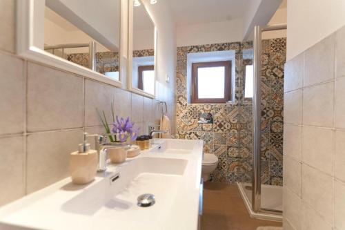 - Baño con 2 lavabos y aseo en 3 holiday apartments with shared pool, peaceful location, en Pula