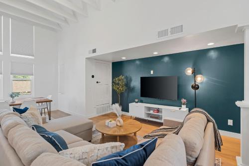 a living room with a couch and a tv at Luxurious Uptown Home - Mountain Views, Pool Table, Workspace, Parking! in Phoenix