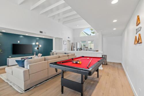 a living room with a couch and a pool table at Luxurious Uptown Home - Mountain Views, Pool Table, Workspace, Parking! in Phoenix