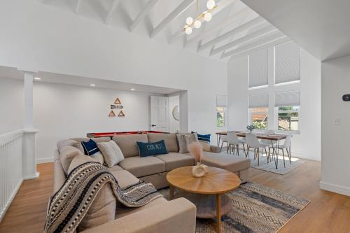 a living room with a couch and a table at Luxurious Uptown Home - Mountain Views, Pool Table, Workspace, Parking! in Phoenix