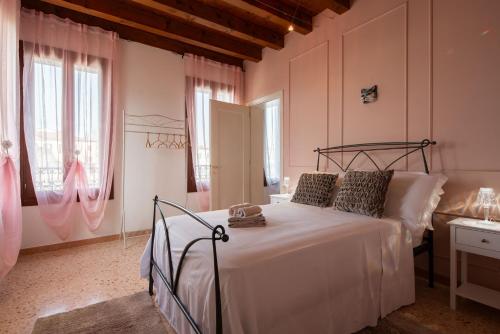 - une chambre avec un lit dans une pièce aux murs roses dans l'établissement Villa Venice Carnival - Wellness, à Mira